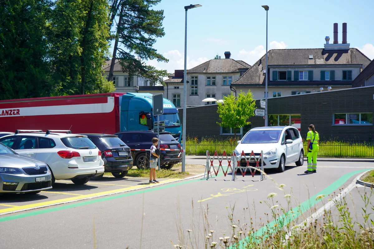Man sieht Autos und ein Sperrgitter. 